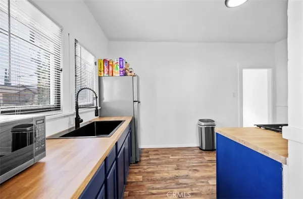 a kitchen with kitchen island granite countertop a sink and refrigerator