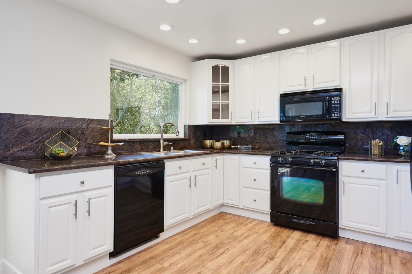 1132 Lassen Drive Belmont, CA 94002 - Photo 8 of 27 a kitchen with stainless steel appliances granite countertop a stove a sink and a microwave