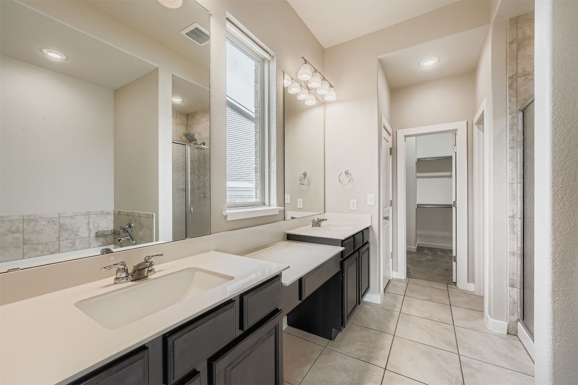 11209 American Mustang Loop Manor, TX 78653 - Photo 18 of 34 a bathroom with a granite countertop sink and a mirror