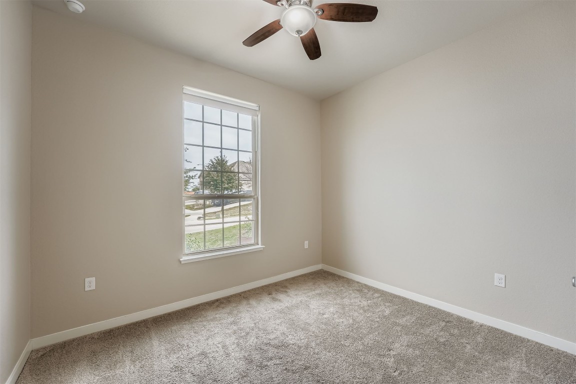 11209 American Mustang Loop Manor, TX 78653 - Photo 20 of 34 an empty room with a window and a ceiling fan