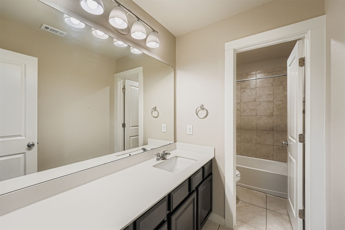 11209 American Mustang Loop Manor, TX 78653 - Photo 27 of 34 a bathroom with a sink a light fixture and a mirror