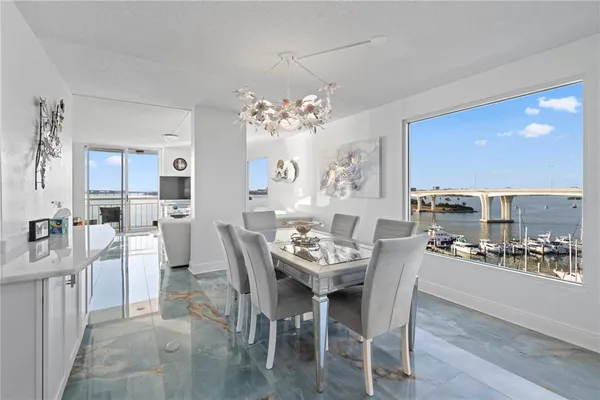 a dining room with furniture a kitchen and chandelier