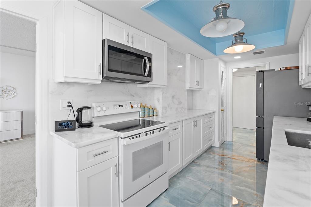 100 Pierce Street, Unit 908 Clearwater, FL 33756 - Photo 24 of 32 a kitchen with stainless steel appliances granite countertop a sink a stove and cabinets