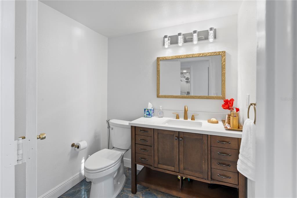 100 Pierce Street, Unit 908 Clearwater, FL 33756 - Photo 27 of 32 a bathroom with a toilet a sink a mirror and vanity