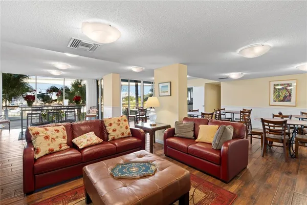 a living room with furniture wooden floor and kitchen view