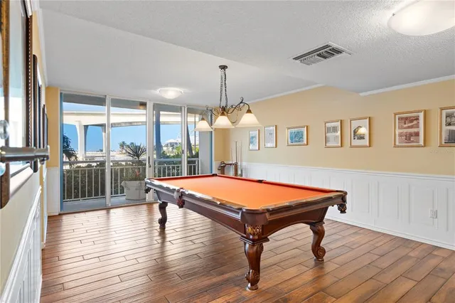 a room with wooden floors and pool table