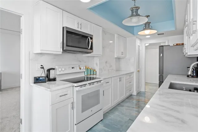 a kitchen with stainless steel appliances granite countertop a sink a stove and cabinets