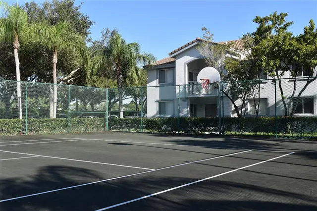 a view of a house with a yard and palm trees