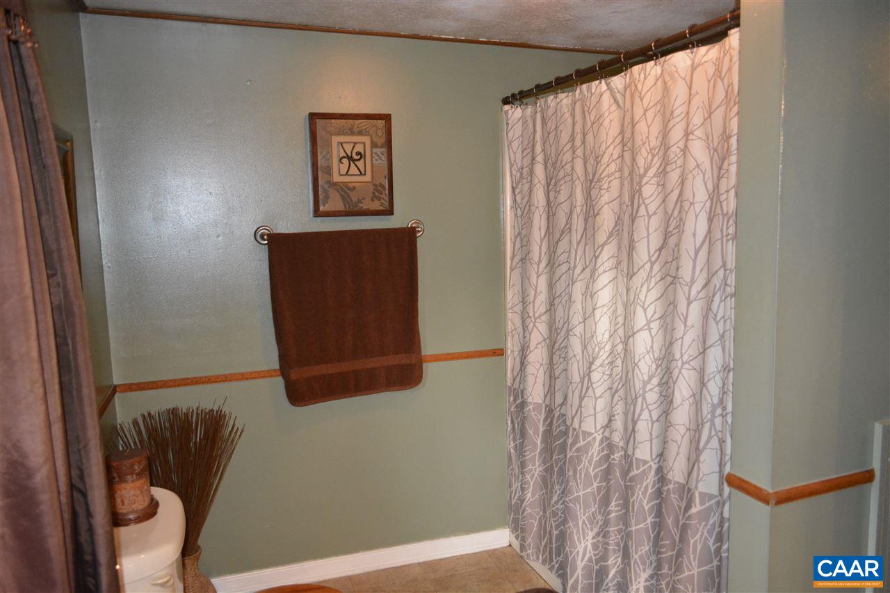 2720 Cedar Lane Road Kents Store, VA 23084 - Photo 18 of 27 a bathroom with a shower curtain and a window