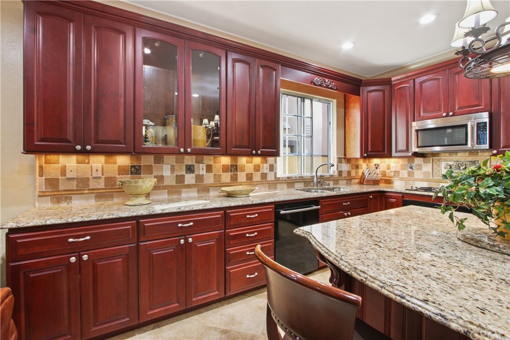 11610 Goetting Avenue Tustin, CA 92782 - Photo 20 of 62 a kitchen with granite countertop wooden cabinets a sink and dishwasher