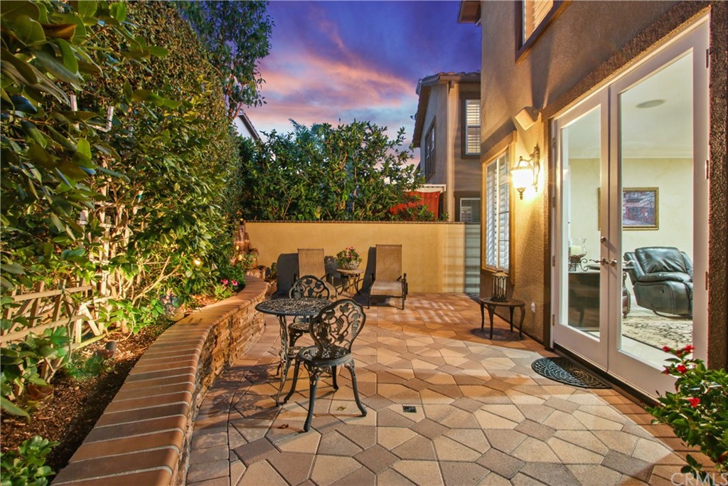 11610 Goetting Avenue Tustin, CA 92782 - Photo 38 of 62 a view of a patio with table and chairs and floor to ceiling window with wooden fence