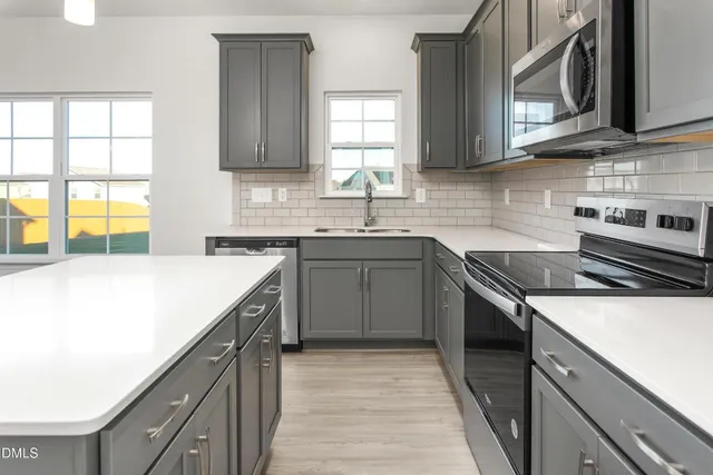 a kitchen with stainless steel appliances granite countertop a sink and a stove