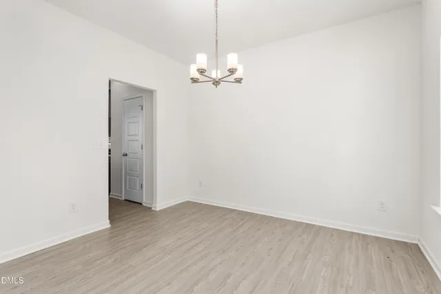 a view of a room with wooden floor and chandelier
