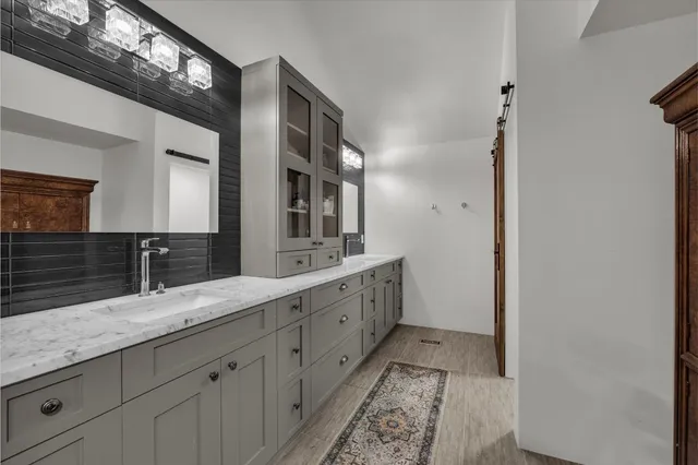 a spacious bathroom with double vanity and a mirror