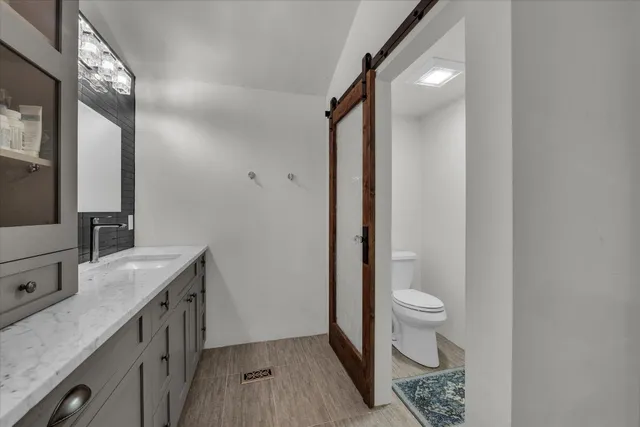 a bathroom with a granite countertop sink toilet and shower