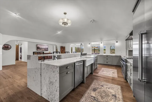a kitchen with stainless steel appliances white cabinets and a stove top oven
