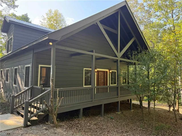 a view of wooden house with a yard and furniture