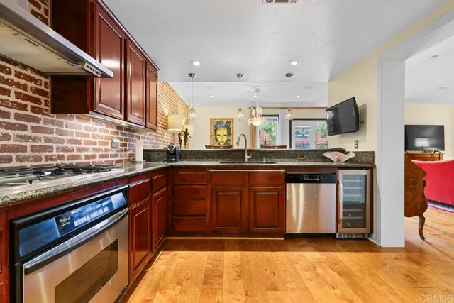 a kitchen with granite countertop stainless steel appliances and wooden cabinets