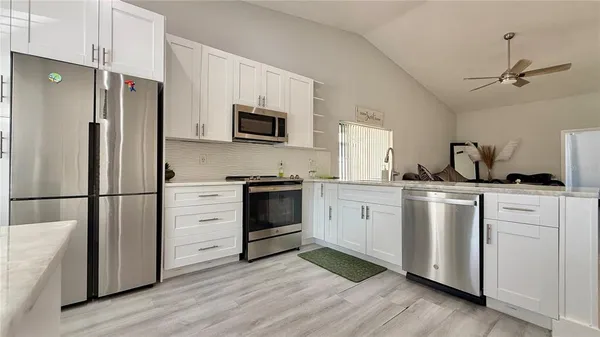 a kitchen with white cabinets and stainless steel appliances