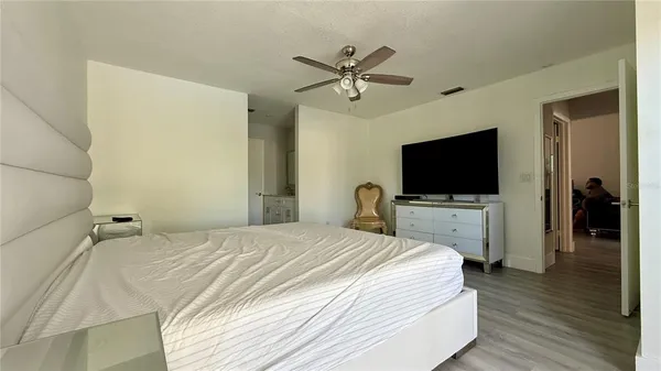 a bedroom with a flat screen tv and a ceiling fan