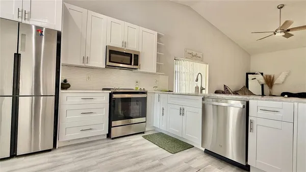 a kitchen with white cabinets and white appliances
