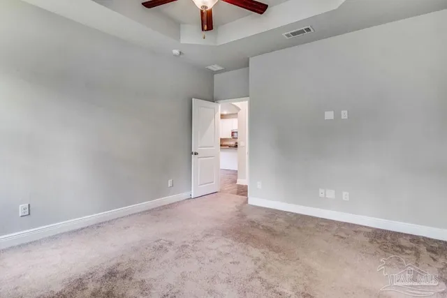 an empty room with a ceiling fan and a window