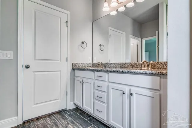 a bathroom with a granite countertop sink and a mirror