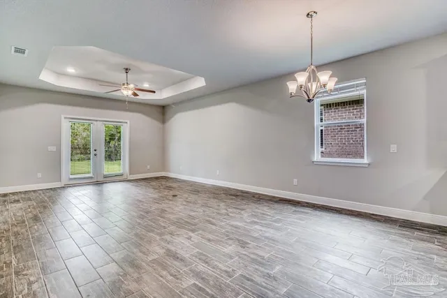 a view of livingroom with window chandelier fan and windows