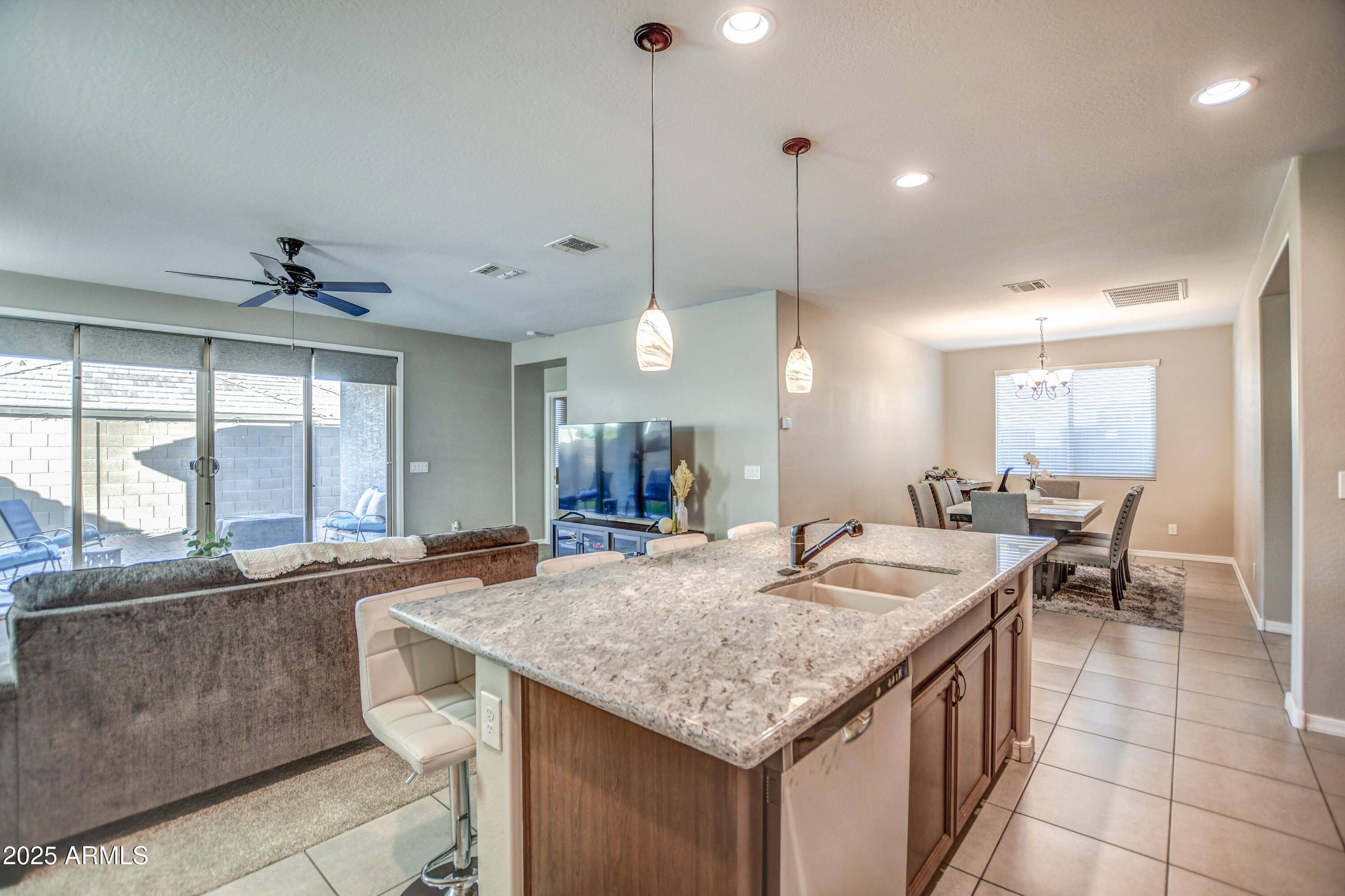 2842 East Fraktur Road Phoenix, AZ 85040 - Photo 30 of 46 a large kitchen with kitchen island a large counter space dining table and stainless steel appliances