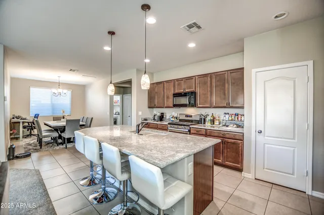 a kitchen with granite countertop a center island stainless steel appliances cabinets and a counter top space