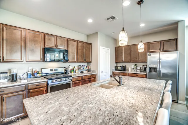 a kitchen with stainless steel appliances granite countertop a sink stove and refrigerator