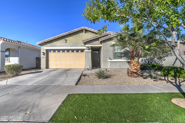 a front view of a house with garden and trees