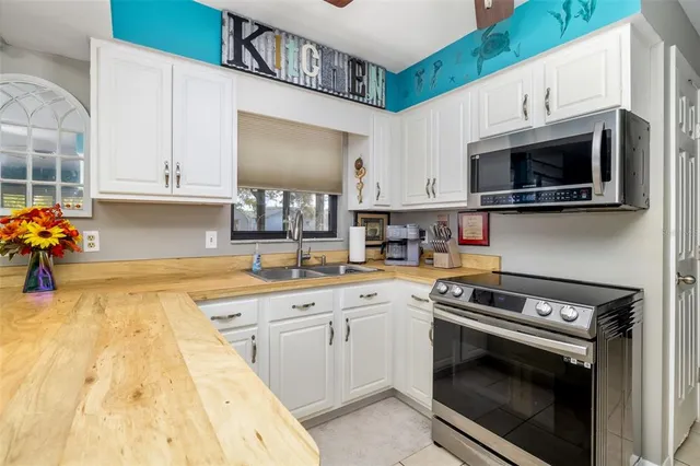 a kitchen with stainless steel appliances a stove a microwave sink and cabinets