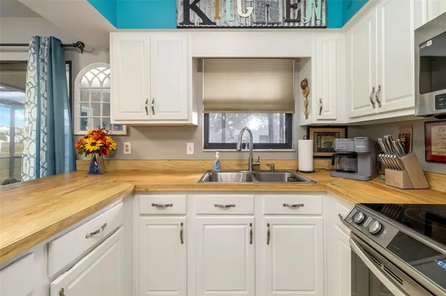 a kitchen with white cabinets and appliances