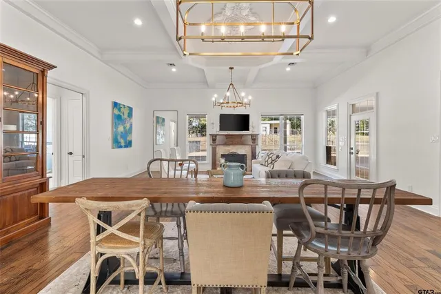 a view of a dining room with furniture a chandelier and wooden floor