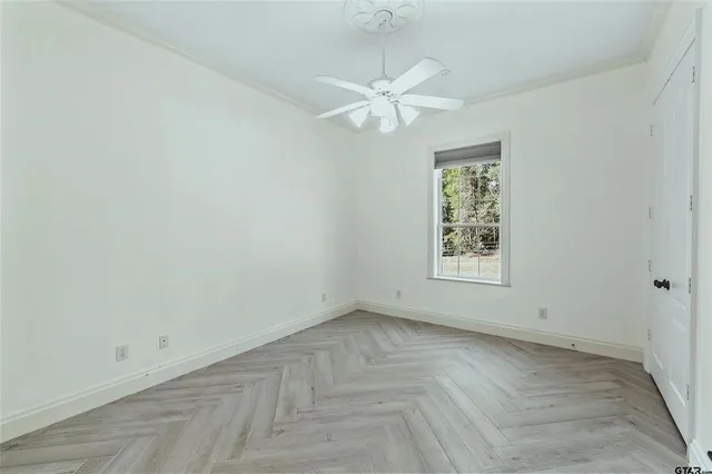 an empty room with a window and a fan