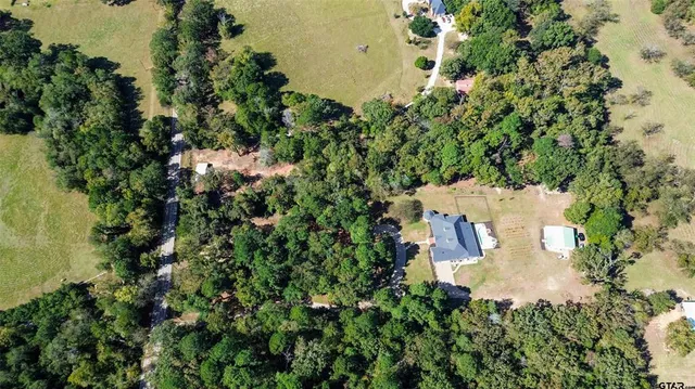 an aerial view of a house with a yard and lake view