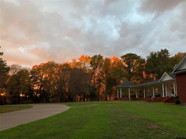 a view of a big yard with a house in the background