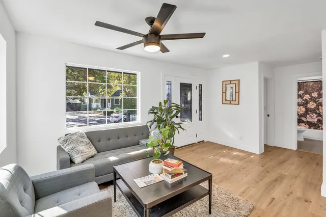 a view of kitchen with stainless steel appliances granite countertop living room dining table and chairs