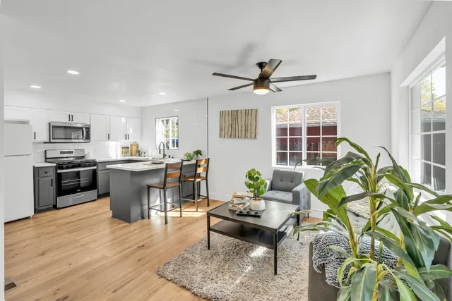 a kitchen with a stove a refrigerator and a dining table