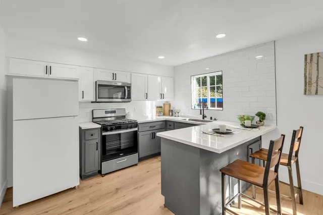 a kitchen with a sink appliances and a window