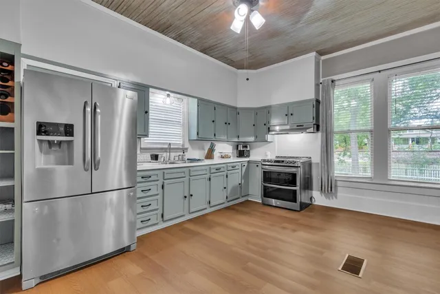 a kitchen with stainless steel appliances granite countertop a refrigerator a stove a sink and a microwave