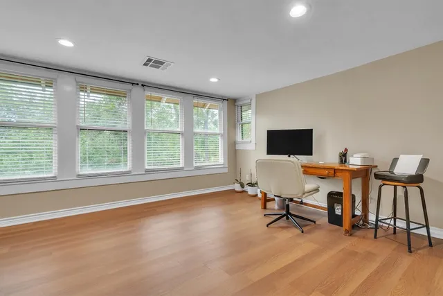 a view of a workspace with furniture and a window