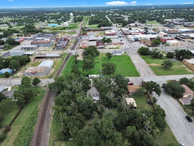 an aerial view of residential houses with outdoor space and trees