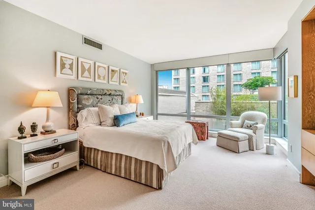 a bedroom with a bed and a large window