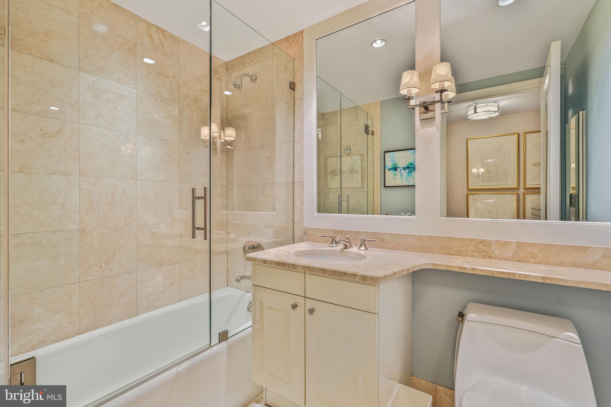 1111 23rd Street Northwest, Unit 4F Washington, DC 20037 - Photo 21 of 27 a bathroom with a granite countertop sink a toilet and shower