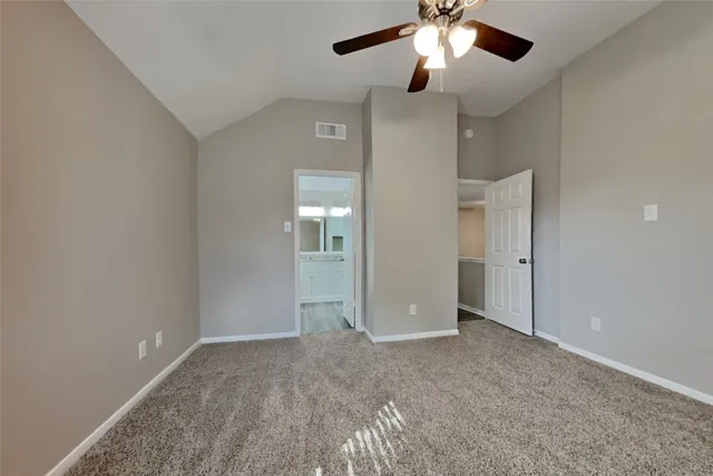 a view of an empty room and a chandelier fan