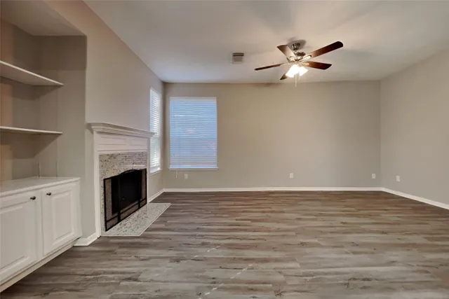a view of an empty room with a fireplace and a window