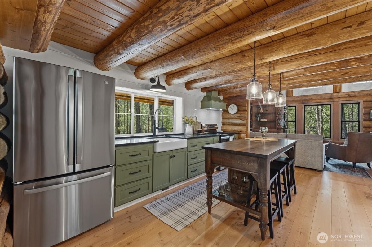 2350 First Crk Road Chelan, WA 98816 - Photo 13 of 39 a kitchen with a refrigerator a sink dishwasher and wooden cabinets with wooden floor