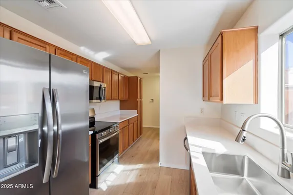 a kitchen with stainless steel appliances granite countertop a sink a stove and a refrigerator